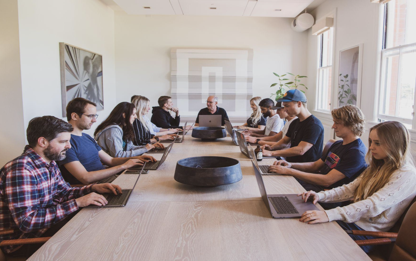Builders working laptops-down around the boardroom table