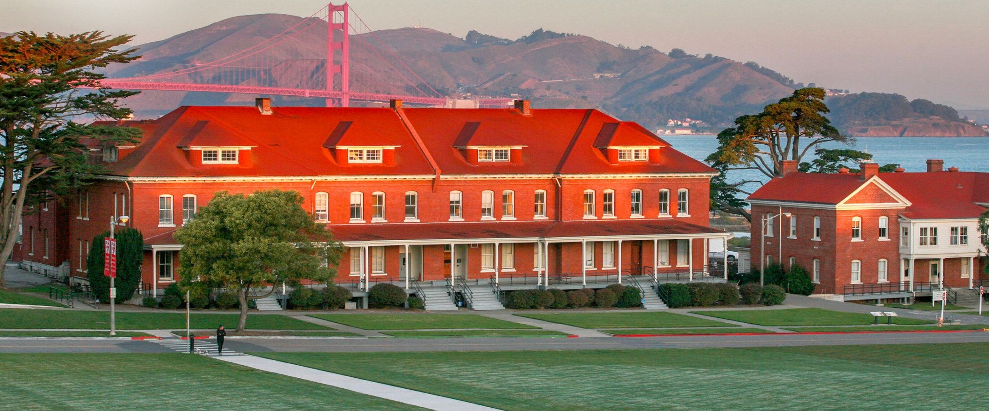 The House — red-brick Presidio building with the Golden Gate Bridge behind it