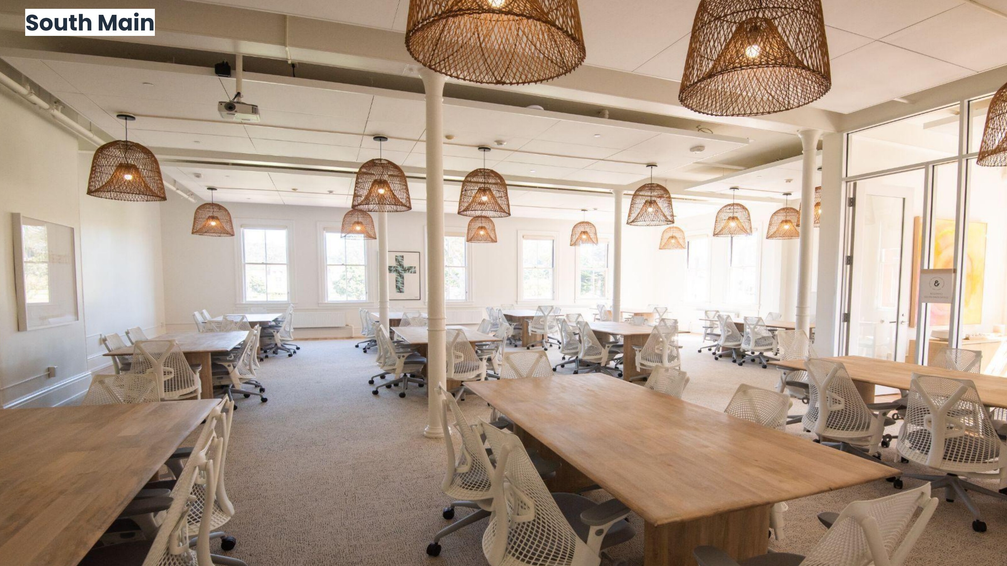 South Main coworking floor with wood tables and woven pendants